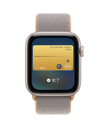 スターライトアルミニウムケースのApple Watch SE 3。画面にウォレットアプリと、支払いに使うカードの画像が表示されている。右側面の外観、Digital Crownのダイヤル。シャンブレーブルー（ライトブルーグレイ）のスポーツループバンド