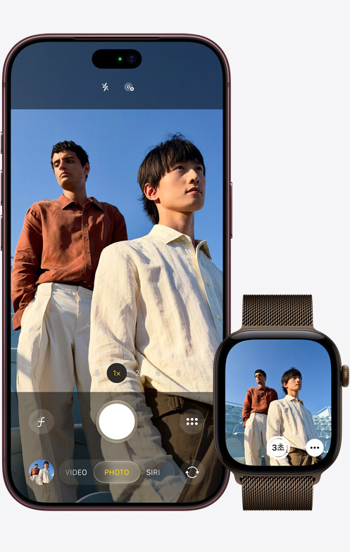 iPhone 18 Pro의 앞면. 카메라를 사용해 파란 하늘을 배경으로 두 남성을 촬영하는 모습. 그 옆에는 카메라 리모컨 앱이 열려 있는 Apple Watch Ultra 3가 있습니다.