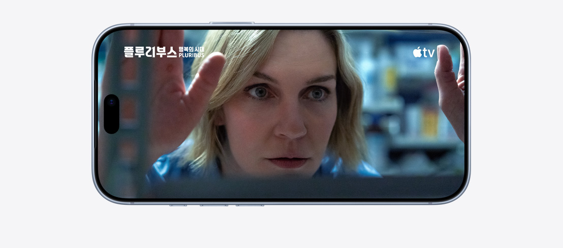 가로 방향으로 놓인 iPhone 18 Pro의 앞면. 화면에는 Apple TV 프로그램 ‘플루리부스: 행복의 시대’가 재생되고 있습니다.