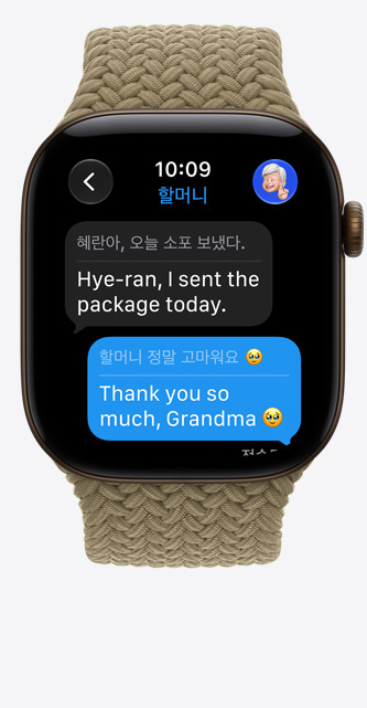 다크 브론즈 색상 알루미늄 케이스의 Apple Watch Series 12. '실시간 번역' 기능이 iMessage의 언어를 영어로 변경하는 모습. 올리브 색상(연한 어스 그린) 브레이드 솔로 루프 밴드를 장착
