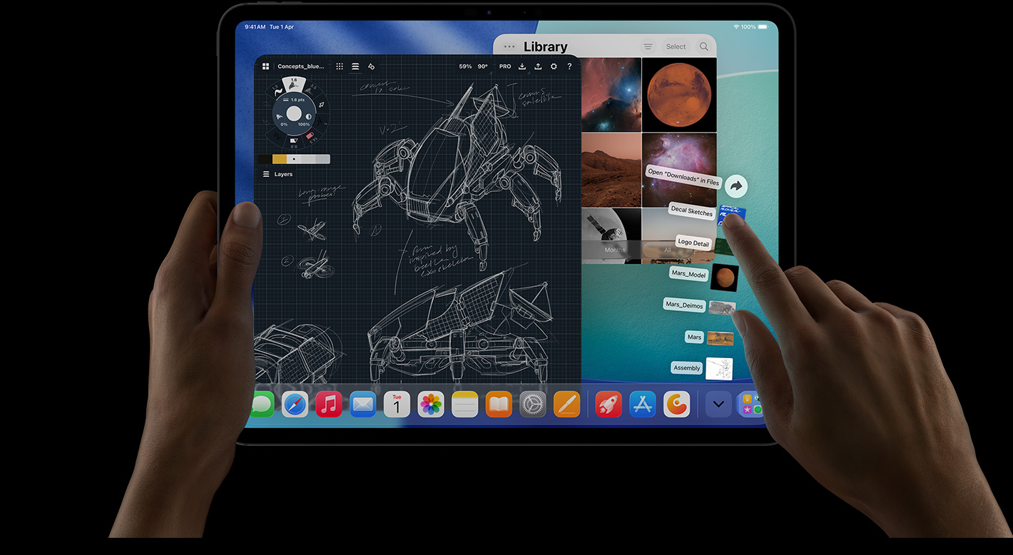 iPad Pro, front exterior, landscape orientation, right hand gesturing over Downloads folder files fanned out, display showing iPadOS interface with multiple open apps including photo editing app with detailed robot blueprints and handwritten annotations and multiple design stages, and Photos Library