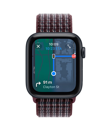 Apple Watch SE 3 z aluminiową kopertą w kolorze północy i opaską sportową w kolorze burgunda w kratkę. Ekran wyświetla aplikację Znajdź (memoji na tle mapy). Na prawym boku urządzenia pokrętło Digital Crown