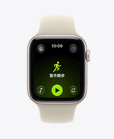 Apple Watch SE 3，展示星光色鋁金屬錶殼，螢幕顯示體能訓練 app (室外跑步)，右側外觀上有數位錶冠轉盤，搭配沙色 (淺小麥色系) 運動型錶帶