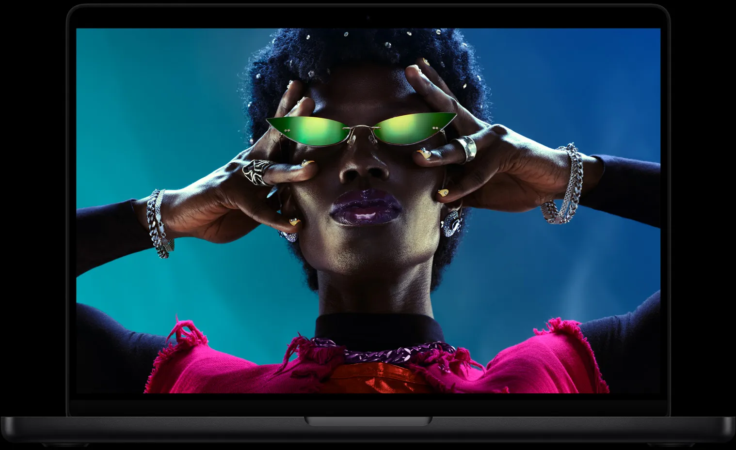 MacBook Pro 螢幕畫面是一個人戴著太陽眼鏡的彩色影像，展示鮮活出色的 Liquid Retina XDR 顯示器