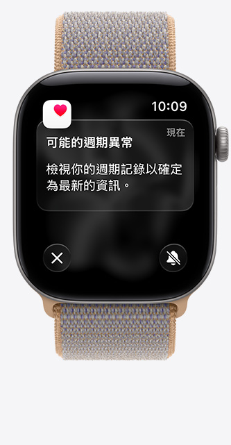 Apple Watch Series 12，展示太空灰色鋁金屬錶殼，搭配水手布藍色 (淡藍灰色系) 運動型錶環，螢幕顯示健康 app 中的經期追蹤功能，以及可能的經期異常通知