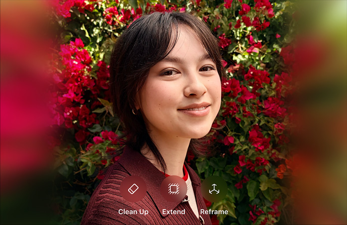 Foto einer lächelnden Person mit braunen Haaren, die einen braunen Pullover trägt und von roten Blumen umgeben ist, AI Demo für die Fotobearbeitung mit den Optionen Bereinigen, Erweitern, Neu ausrichten, die über dem Foto angezeigt werden